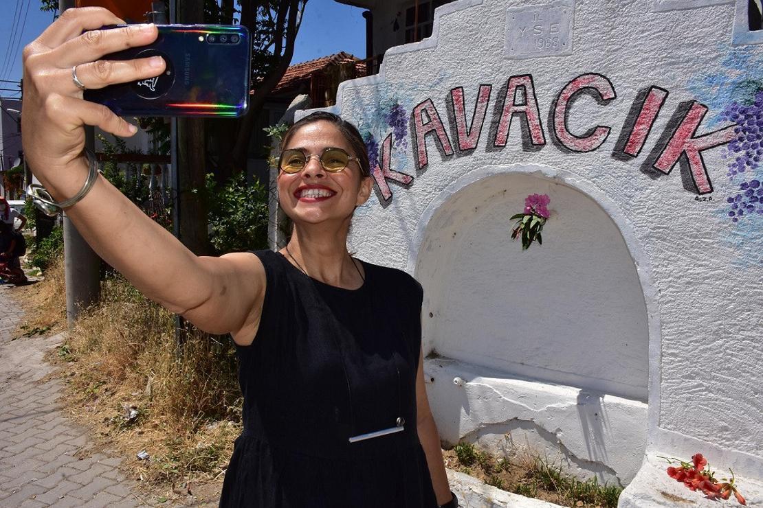 Tuval olan köy duvarları önünde hatıra fotoğrafı çektiriyorlar