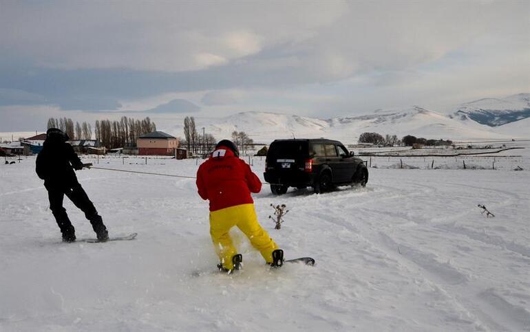 Arazi aracıyla karda snowboard yaptılar