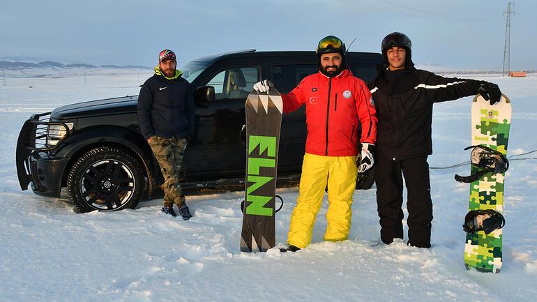 Arazi aracıyla karda snowboard yaptılar