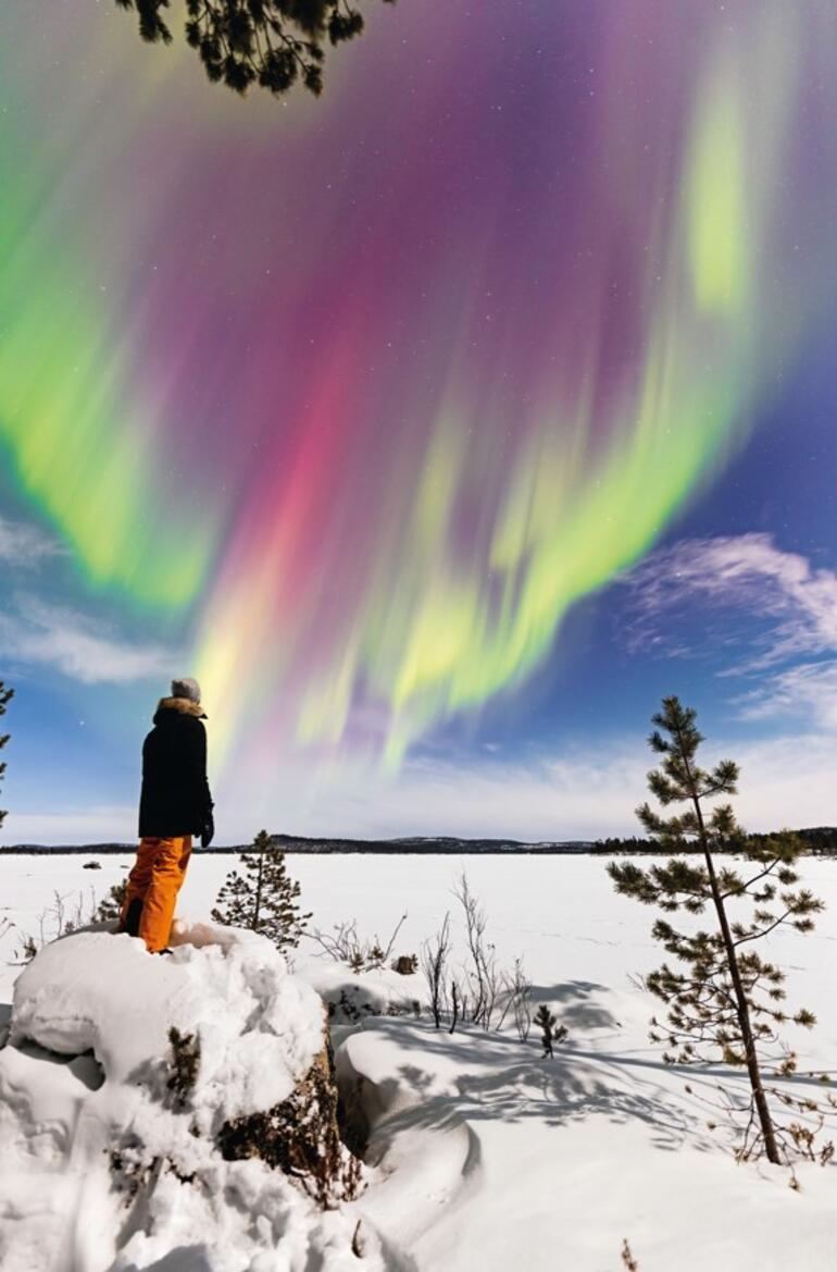 Un paese delle meraviglie bianco sotto l'aurora boreale colorata