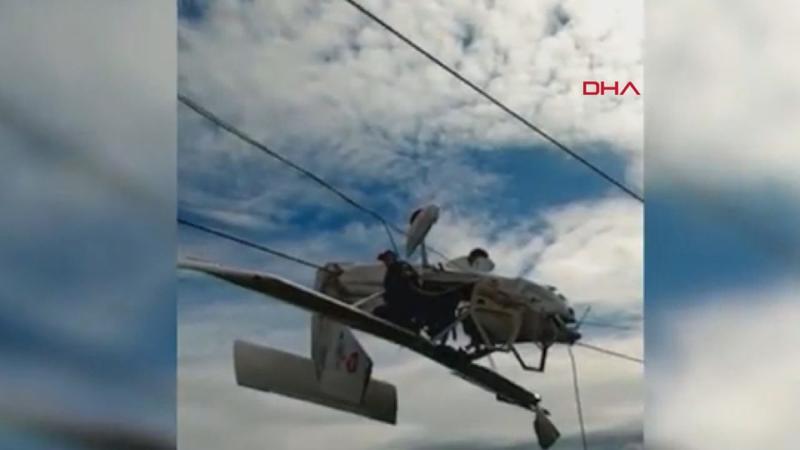 Uçak elektrik tellerinde asılı kaldı, pilot kanada oturup kurtarılmayı bekledi