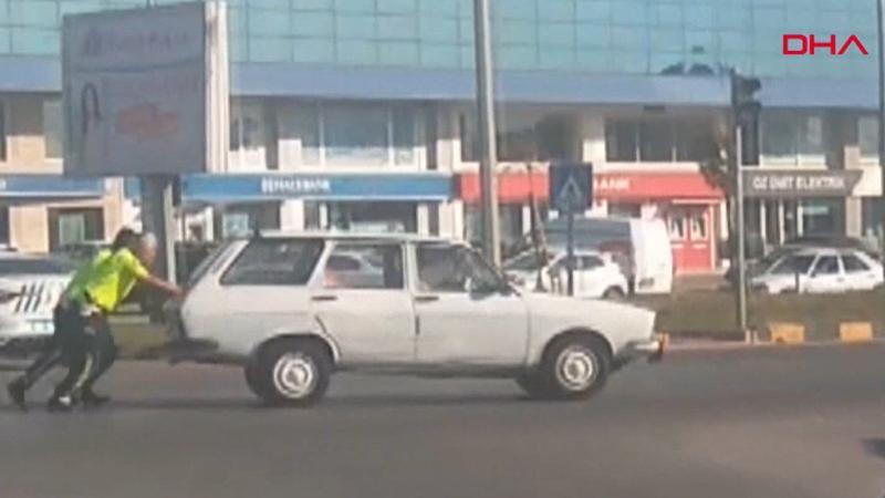 Yol ortasında bozulan aracı, trafik polisleri itti