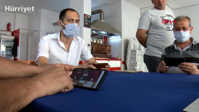 Koronavirüs yüzünden kahvehanede cep telefonuyla okey oynadılar