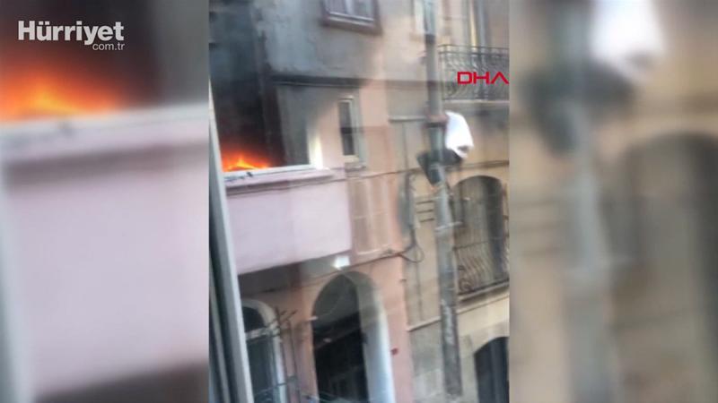 Çıkan yangında aydınlatma direğinden kayarak kaçtı