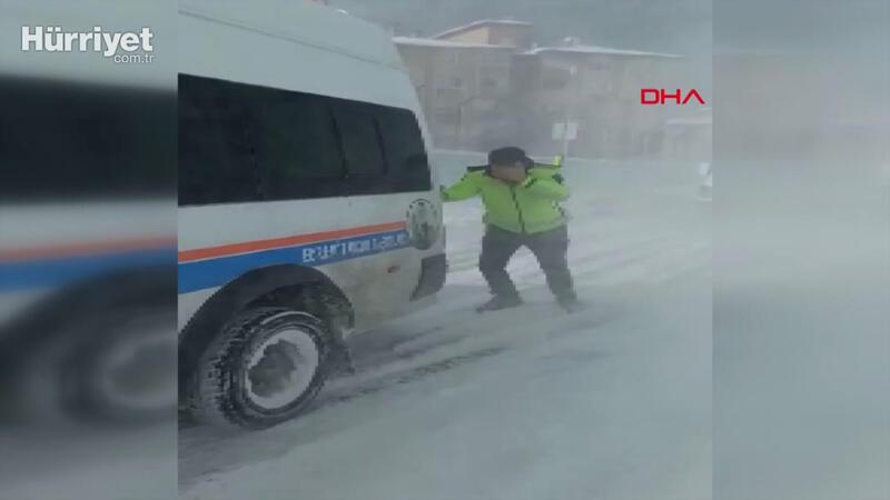 Kar ve tipide öğrenci servisini iten trafik polisinin zor anları kamerada