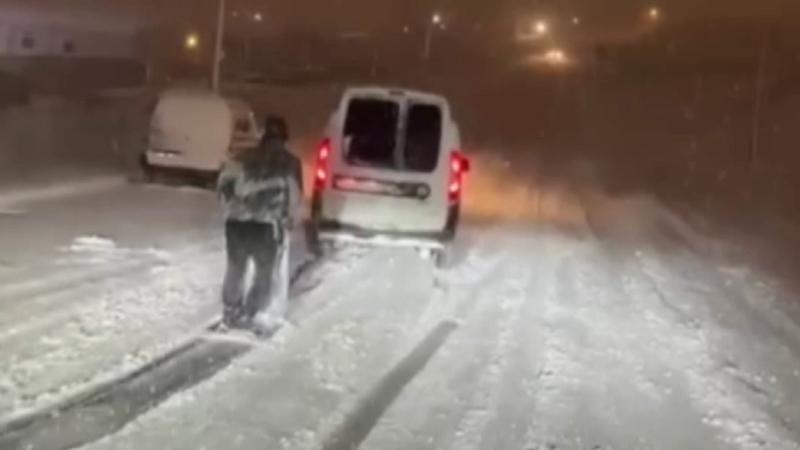 Aracın arkasında bağladığı tahtayla karda sörf yaptı