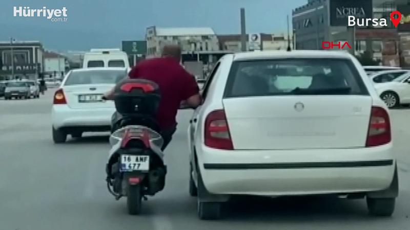 Motosikletli, otomobilin kapısına tutunarak sürücüyle sohbet etti